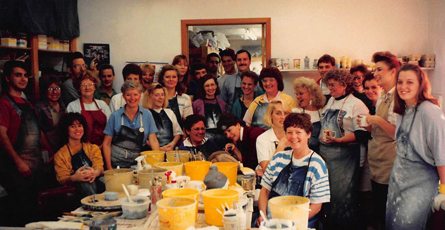 Isabel Bloom employees gathered around a table and supplies