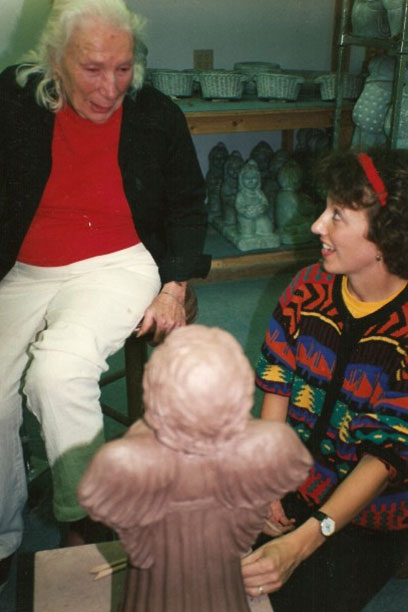 Isabel Bloom sitting casually in her studio with apprentice artist.