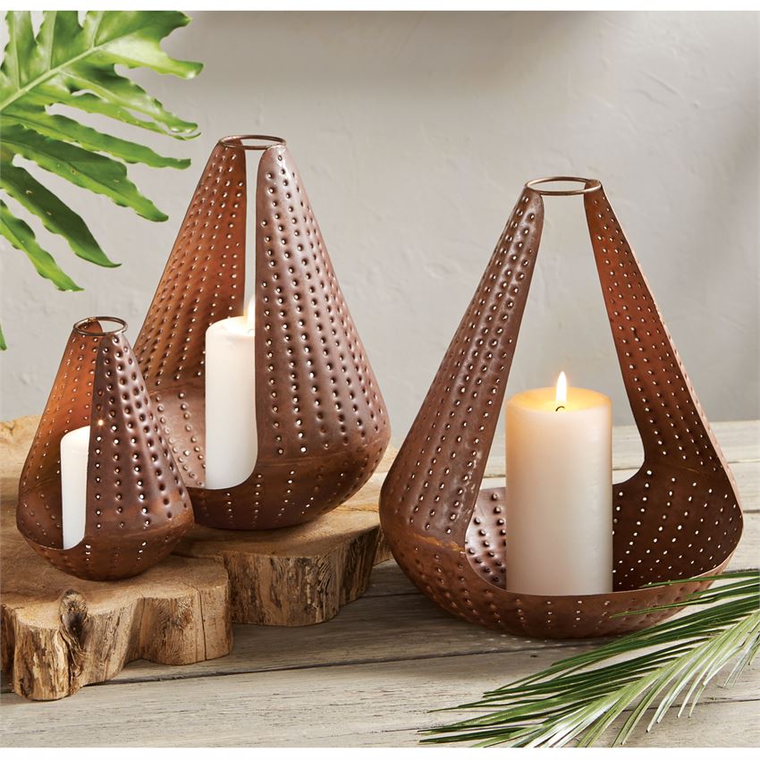 Nested set of three brass finished tin lanterns feature tear drop shape with ring top handle. Pierced sides allow for light to pass through. Candles not included. Lantern Set -Tear Drop