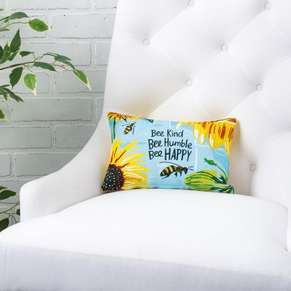A double sided cotton pillow featuring a hand lettered Bee Kind Bee Humble Bee Happy sentiment with bee and sunflower designs on the front and coordinating bee and honeycomb designs on the back Pillow Bee Kind