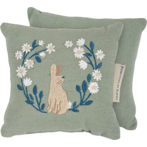 A cotton-linen blend mini pillow displaying a charming bunny surrounded by flowers on soft grass green background. Bunny pillow features embroidered design for added interest and polyester filling. This accessory is part of our IB Home Accents line and was carefully selected to complement our unique sculptures.