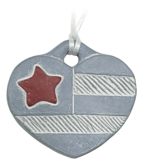 Patriotic Heart Ornament Blue concrete heart ornament with red star and white stripes, inspired by the American flag, hanging as patriotic decor